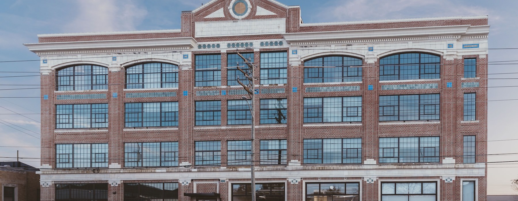 a large brick building with a parking lot in front