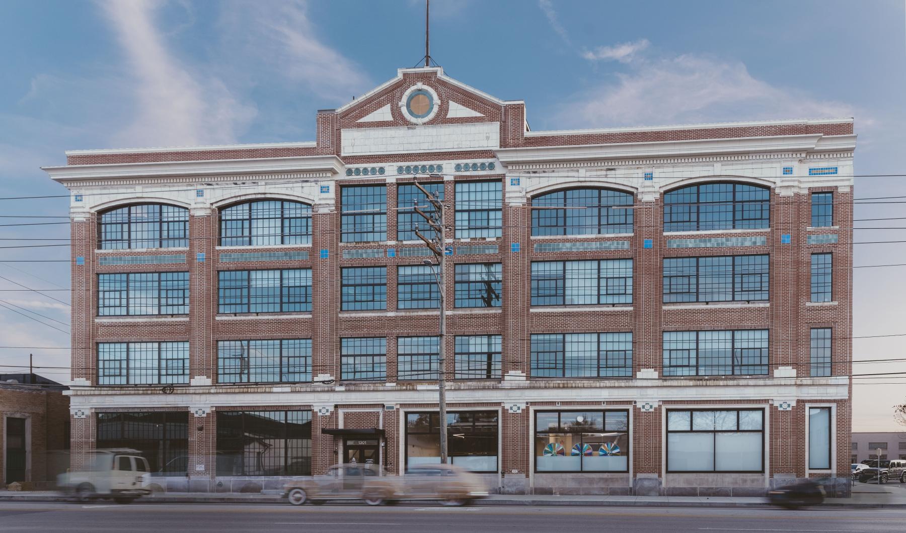 a large brick building with a parking lot in front